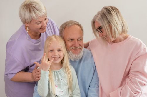 A joyful multigenerational family poses and smiles together indoors, showcasing love and togetherness.
